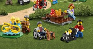 La boîte Lego Cities avec au milieu en bas de l'image la figurine en fauteuil roulant avec son chien guide